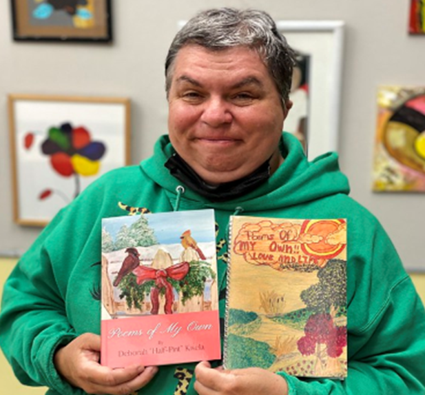 TASK patron Deb Kisela poses with books she has published with the help of TASK