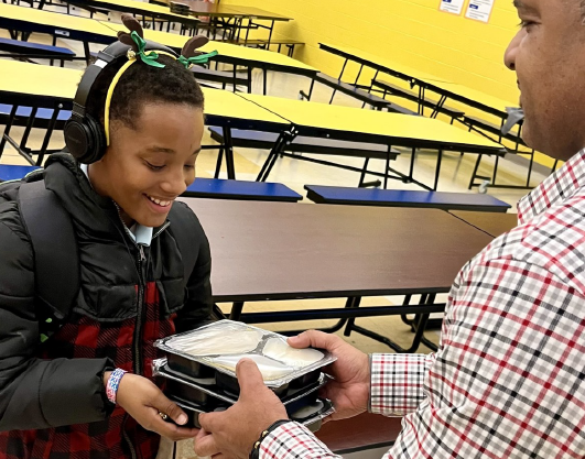 A student receives free TASK meals for his household as part of the STEAMpark after-school program at Clara Parker Intermediate School.